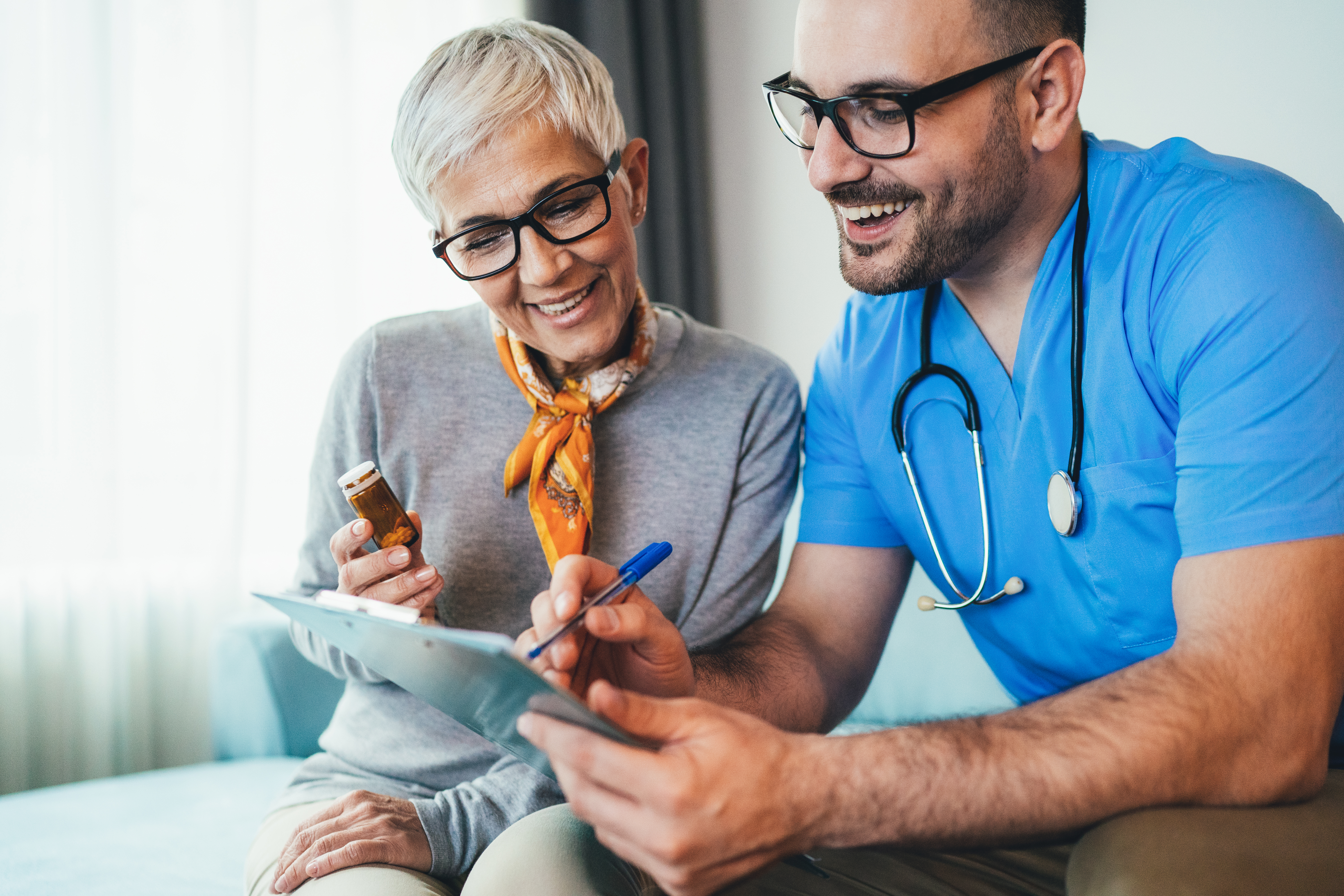 Smiling woman and a medical worker looking at a tablet